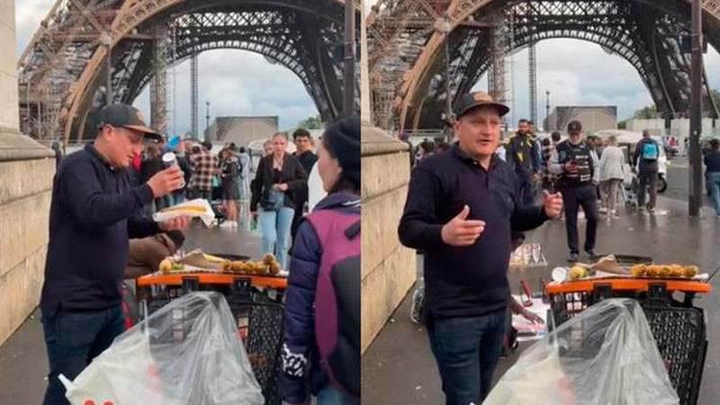 Joven vende elotes al lado de la Torre Eiffel en París 