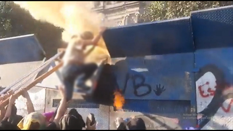 Elementos policiales derriban a manifestantes de vallas metálicas en Ciudad de México 