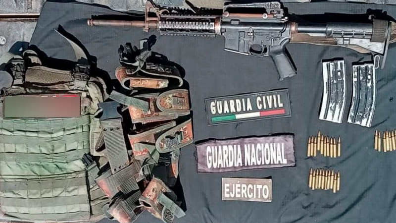 Elementos de seguridad encuentran armamento, municiones y equipo táctico tirado en un camino rural de Aguililla, Michoacán 