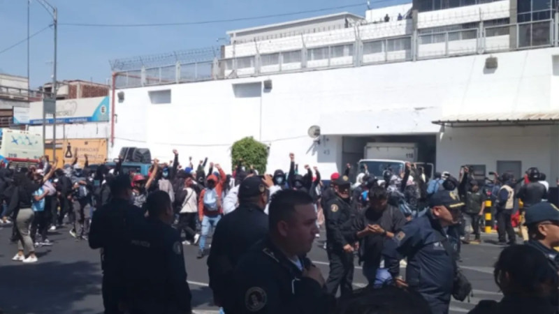 Normalistas vandalizan y derriban puerta del Centro Federal de Arraigos de la FGR 