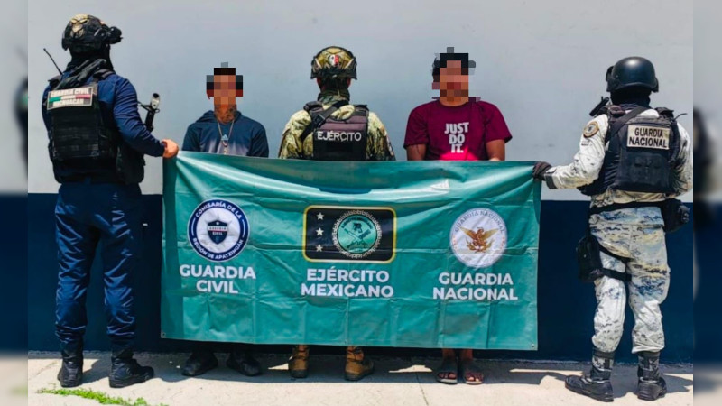 Caen dos sujetos con lonas de grupo criminal, estupefaciente y una moto, en Apatzingán, Michoacán 